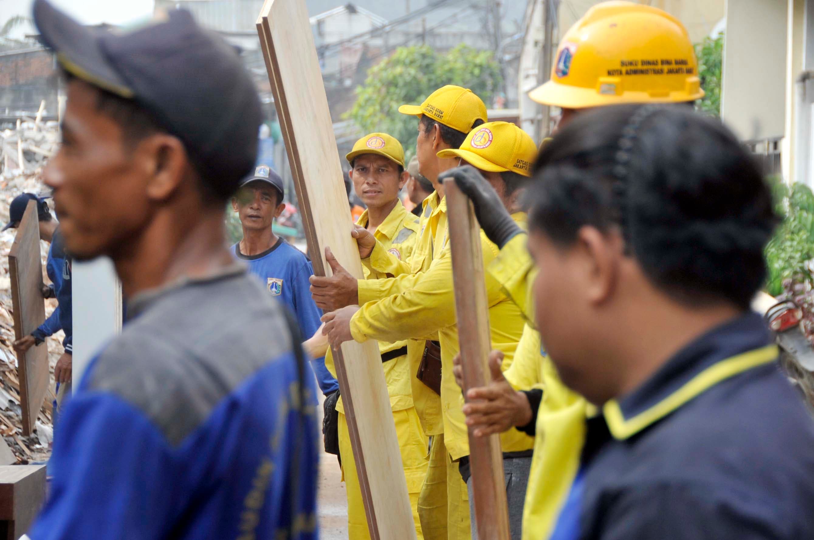 Petugas melakukan pengamanan barang-barang milik bangunan yang akan dibongkar yang telah berdiri di atas lahan aset Taman di kawasan Komplek BTN, Kembangan Utara, Jakarta Barat, Kamis (29/10/2026).  AKURAT.CO/Sopian