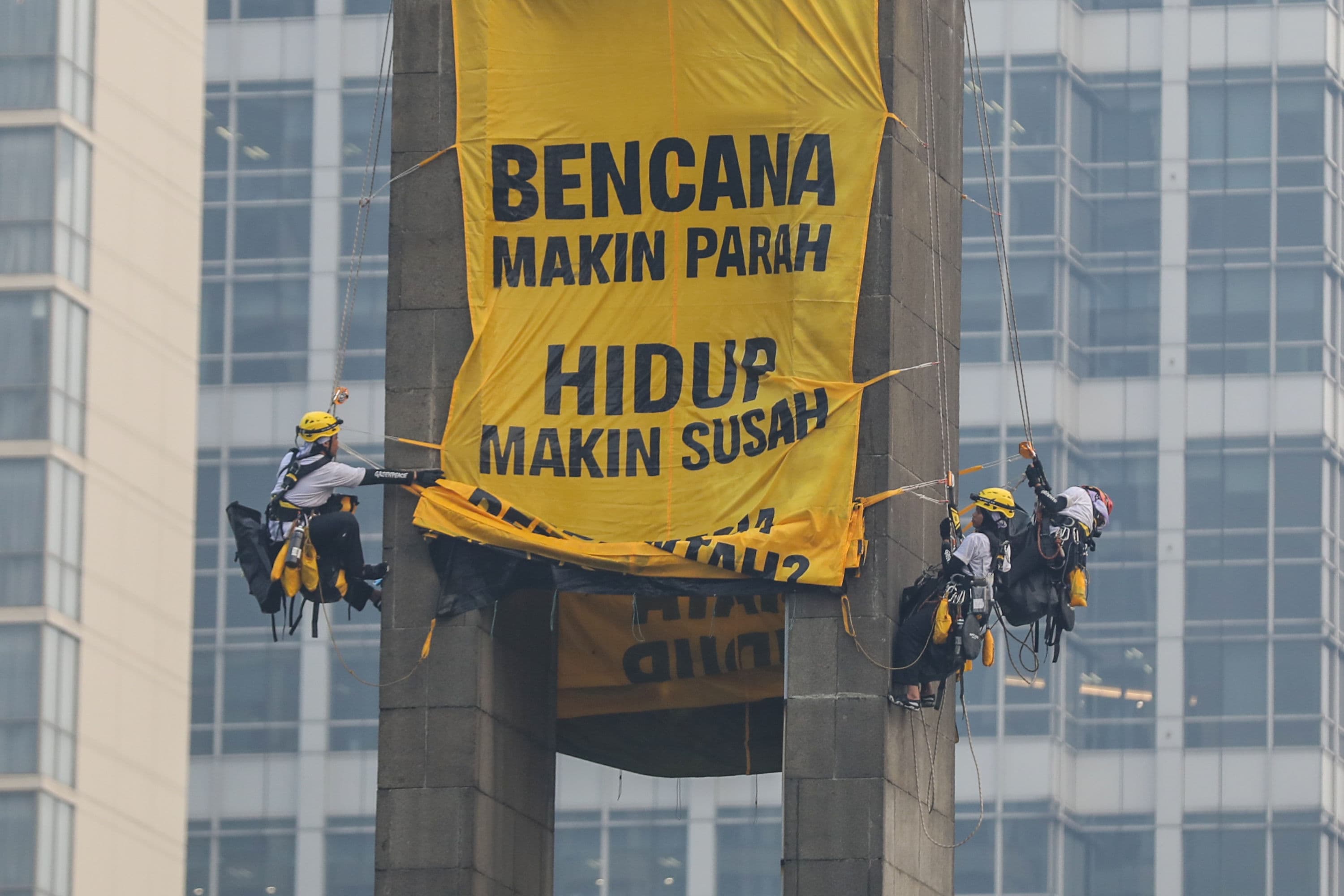 Aktivis Greenpeace membentangkan spanduk di Bundaran HI, Jakarta, Selasa (20/10/2026). AKURAT.CO/Endra Prakoso