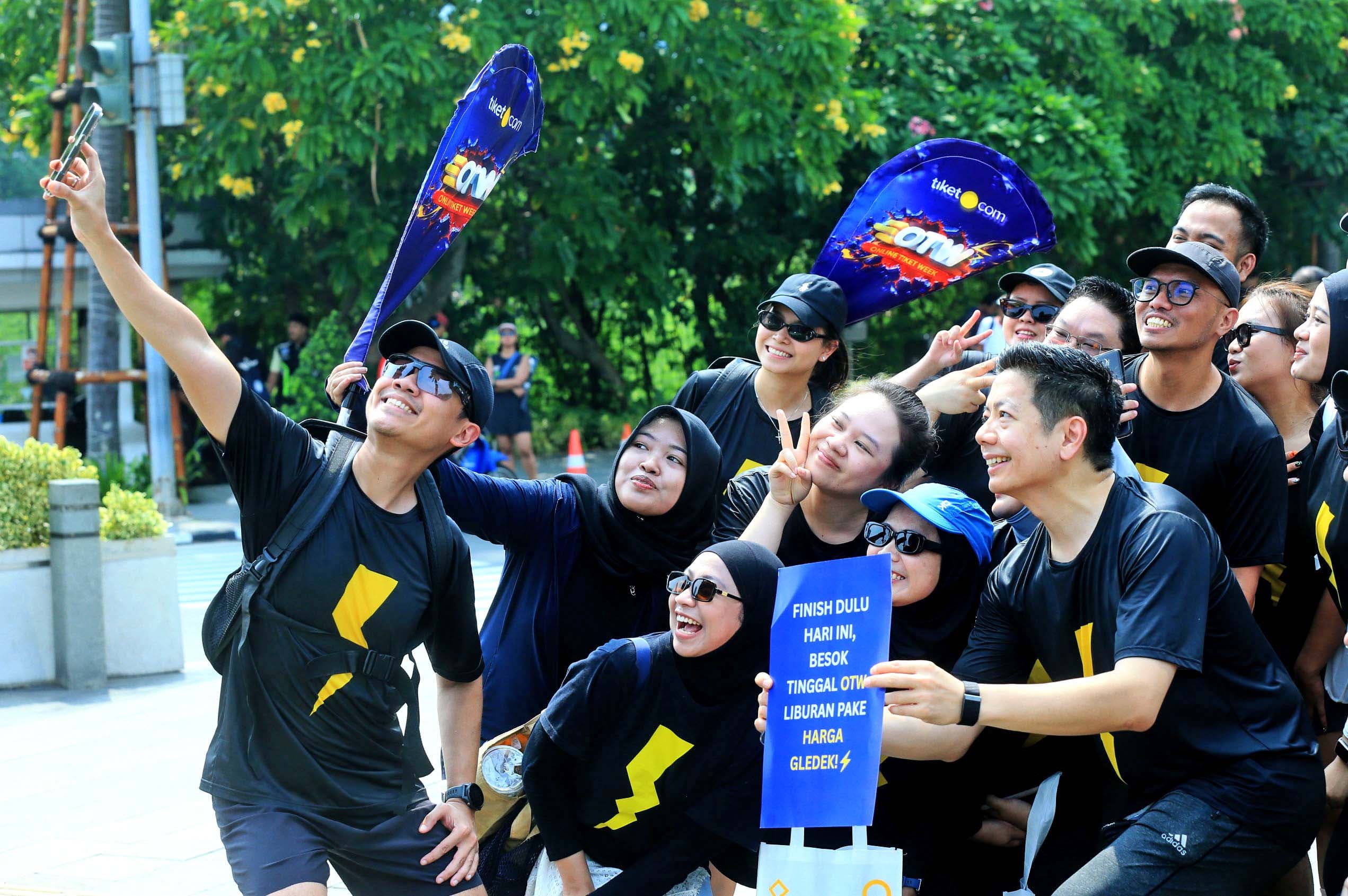 Komunitas lari tiket.com, tiket runners, melakukan pemanasan sebelum memulai lari pagi bersama di kawasan Pacific Place, Jakarta. 