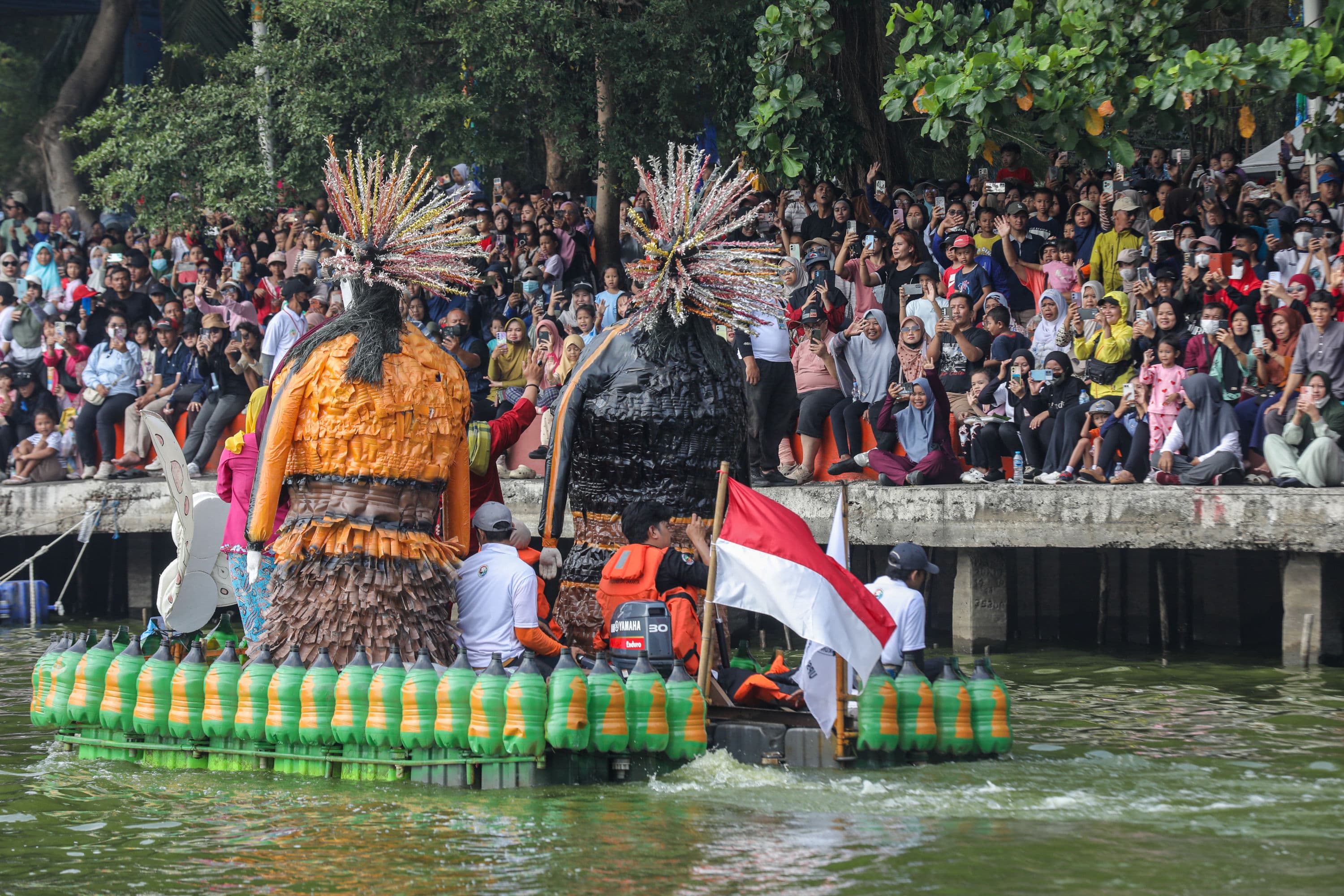 Peserta menaiki perahu berbahan limbah plastik saat parade Festival Cinta Lingkungan (CiLung) di Danau Sunter, Jakarta, Minggu (18/10/2026).AKURAT.CO/Endra Prakoso