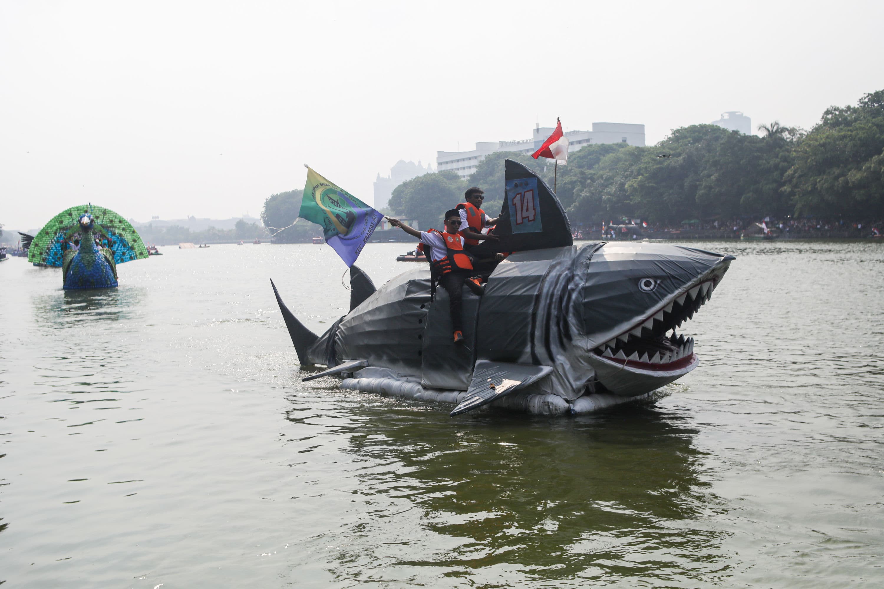 Peserta menaiki perahu berbahan limbah plastik saat parade Festival Cinta Lingkungan (CiLung) di Danau Sunter, Jakarta, Minggu (18/10/2026).AKURAT.CO/Endra Prakoso