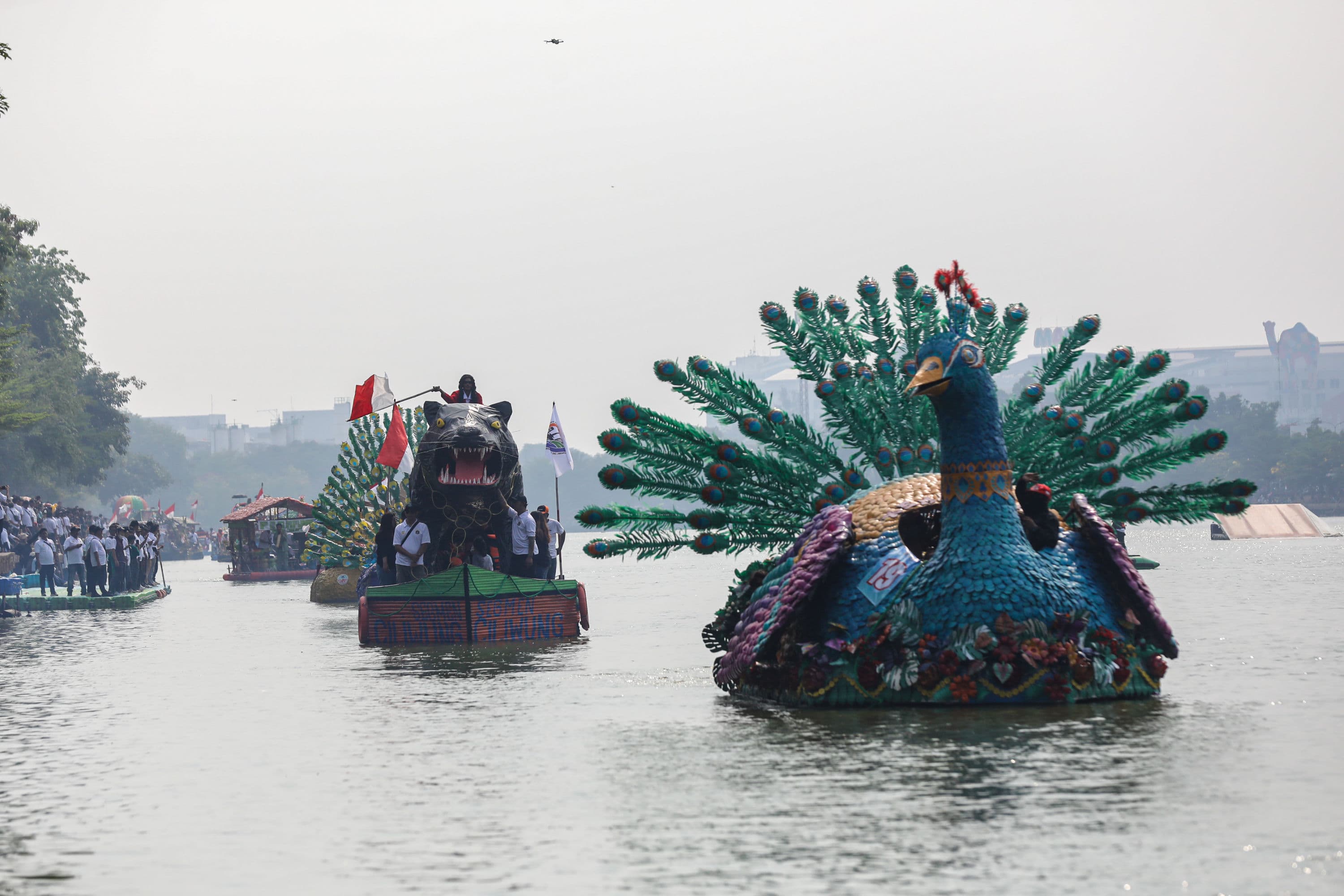 Peserta menaiki perahu berbahan limbah plastik saat parade Festival Cinta Lingkungan (CiLung) di Danau Sunter, Jakarta, Minggu (18/10/2026).AKURAT.CO/Endra Prakoso