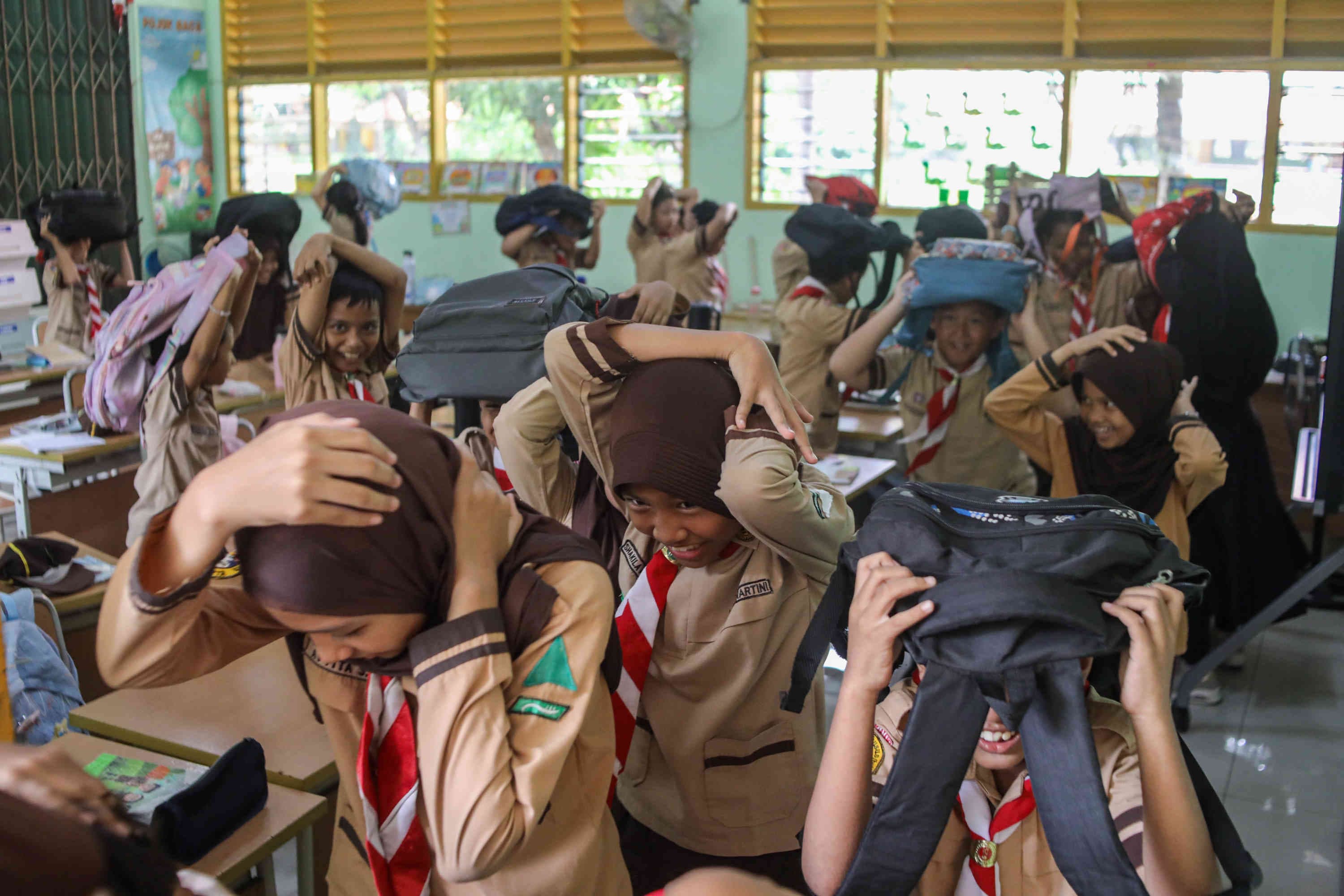 Pelajar mengikuti simulasi gempa bumi di SDN Guntur 01, Jakarta, Rabu (21/10/2026). AKURAT.CO/Endra Prakoso