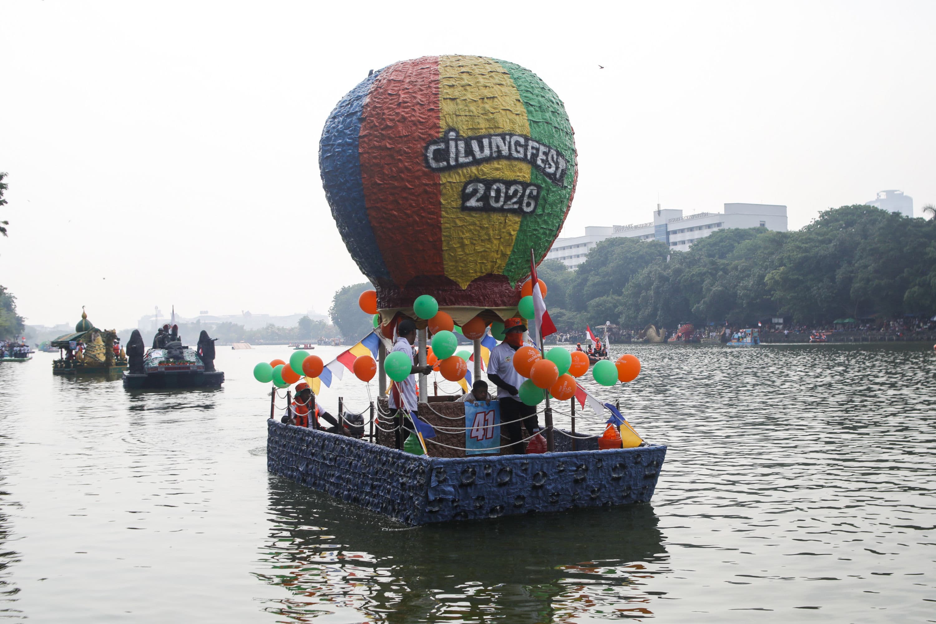 Peserta menaiki perahu berbahan limbah plastik saat parade Festival Cinta Lingkungan (CiLung) di Danau Sunter, Jakarta, Minggu (18/10/2026).AKURAT.CO/Endra Prakoso