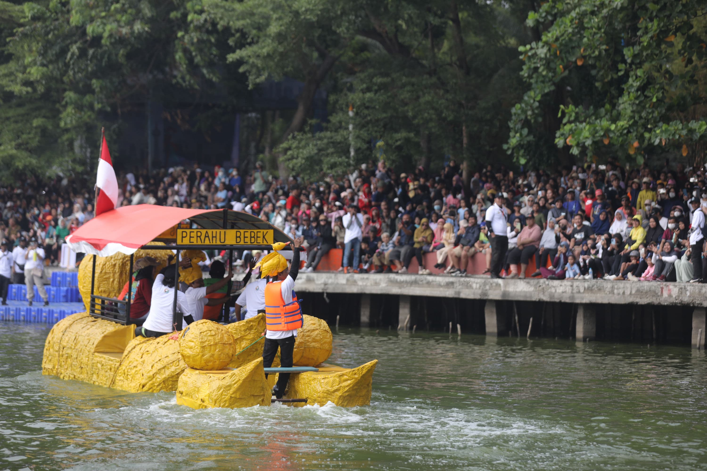 Peserta menaiki perahu berbahan limbah plastik saat parade Festival Cinta Lingkungan (CiLung) di Danau Sunter, Jakarta, Minggu (18/10/2026).AKURAT.CO/Endra Prakoso