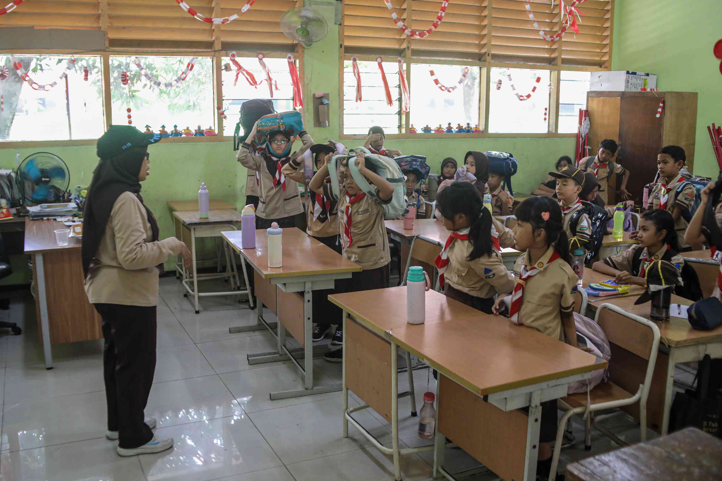 Pelajar mengikuti simulasi gempa bumi di SDN Guntur 01, Jakarta, Rabu (21/10/2026). AKURAT.CO/Endra Prakoso