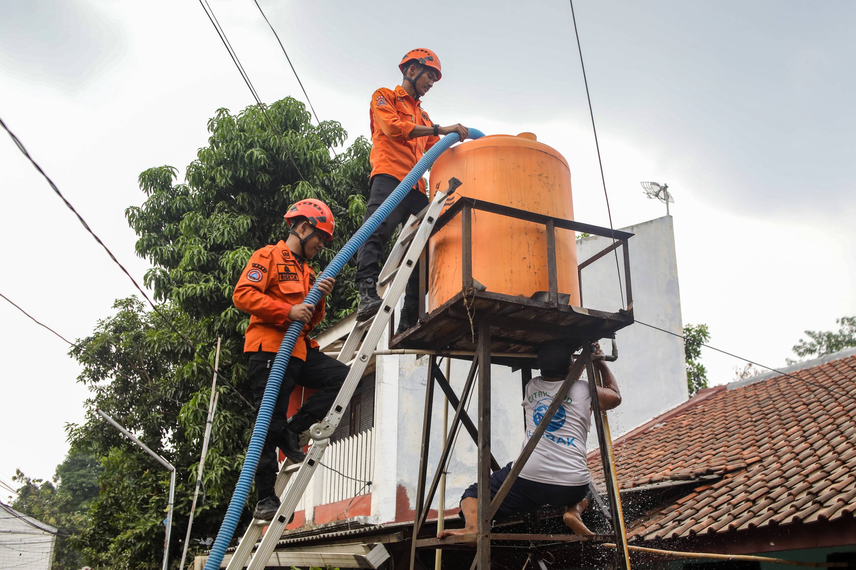 Personel BPBD Jakarta Selatan mengisi air ke dalam wadah milik warga yang terdampak kekeringan di Lenteng Agung, Jakarta, Jumat (18/9/2026). AKURAT.CO/Endra Prakoso