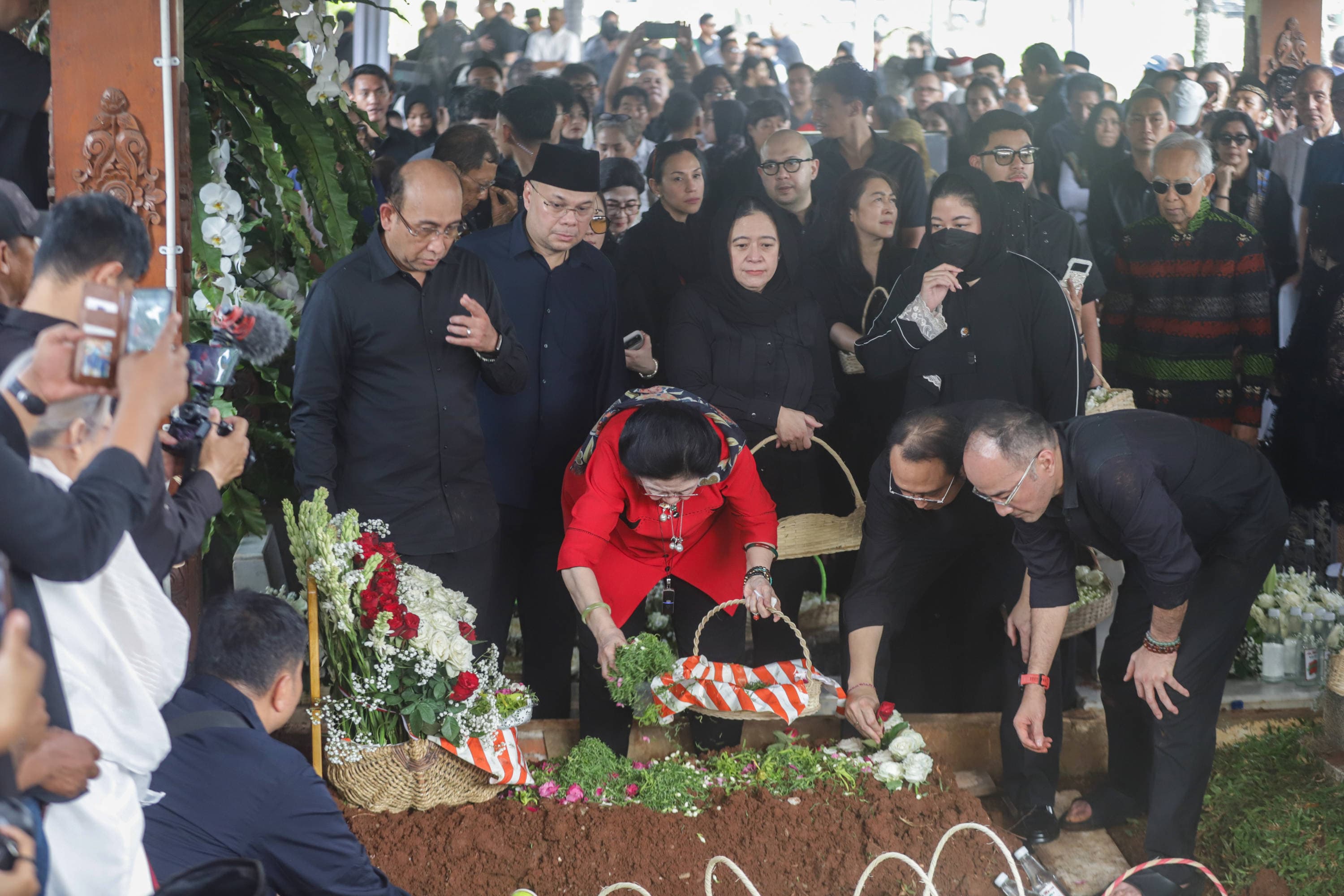 Presiden ke-5 RI Megawati Soekarnoputri (tengah), bersama anaknya Puan Maharani dan Prananda Prabowo menaburkan bunga di atas makam mendiang adiknya, Guruh Soekarnoputra di TPU Karet Bivak, Jakarta, Sabtu (26/9/2026). AKURAT.CO/Endra Prakoso