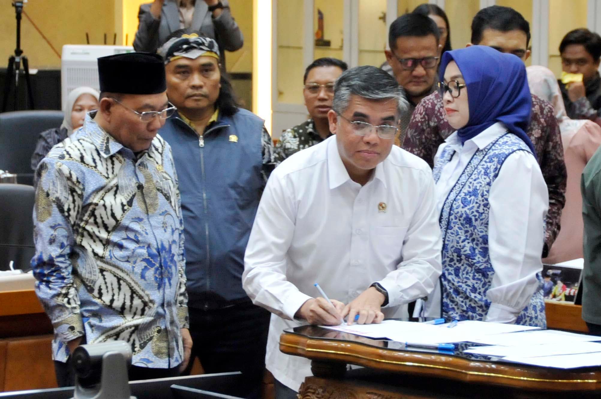 Menteri Ketenagakerjaan (Menaker) Yassierli dan pimpinan Komisi IX saat menandatangani dokumen pengambilan keputusan tingkat I Rancangan Undang-Undang (RUU) tentang Perlindungan Ketenagakerjaan bersama Panitia Kerja (Panja) di Komisi IX DPR, Kompleks Parlemen Senayan, Jakarta Pusat, Senin (5/10/2026) malam. AKURAT.CO/Sopian