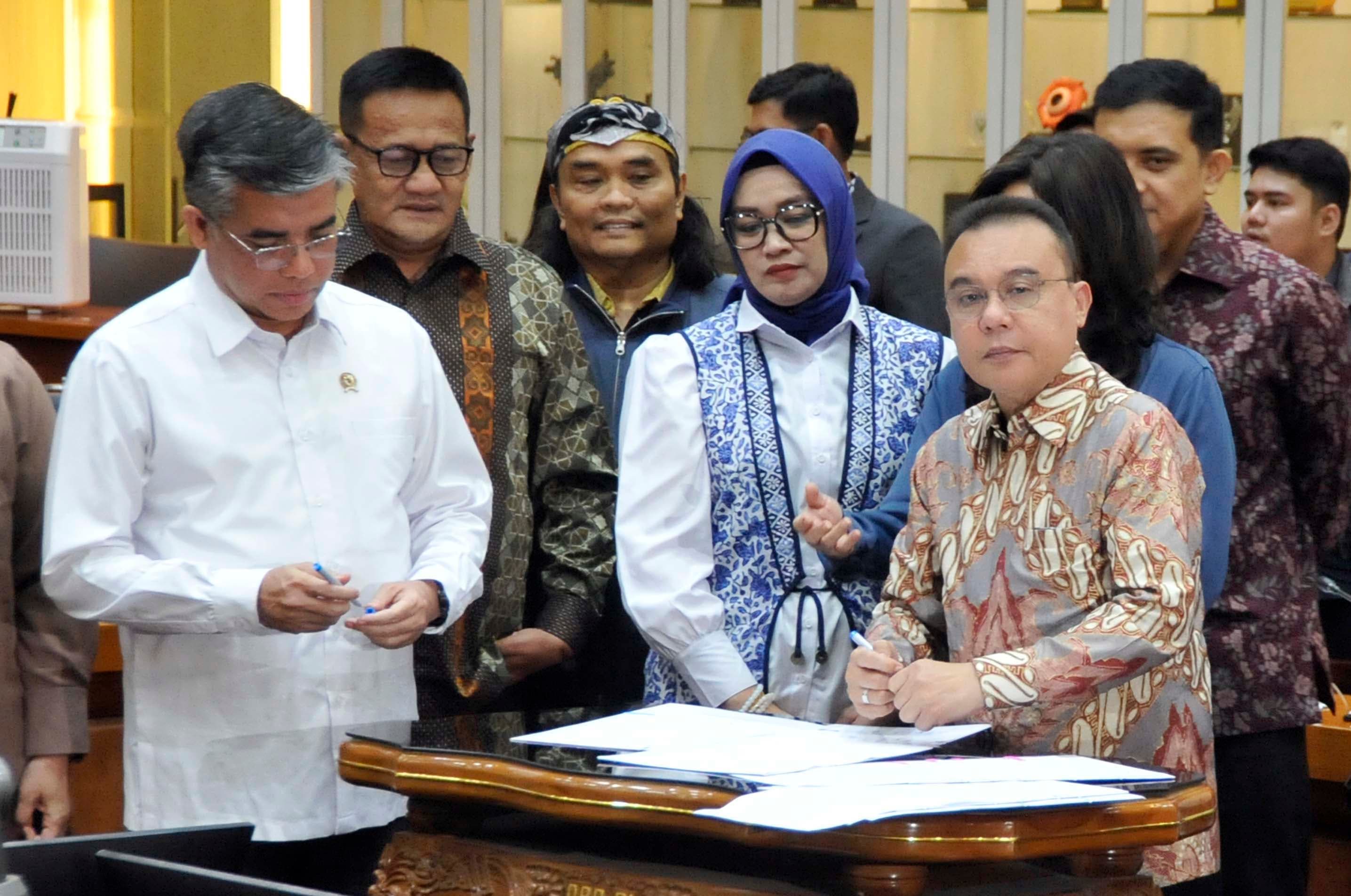 Wakil Ketua DPR RI Sufmi Dasco Ahmad (kanan) bersama Menteri Ketenagakerjaan (Menaker) Yassierli dan pimpinan Komisi IX saat menandatangani dokumen pengambilan keputusan tingkat I Rancangan Undang-Undang (RUU) tentang Perlindungan Ketenagakerjaan bersama Panitia Kerja (Panja) di Komisi IX DPR, Kompleks Parlemen Senayan, Jakarta Pusat, Senin (5/10/2026) malam. AKURAT.CO/Sopian
