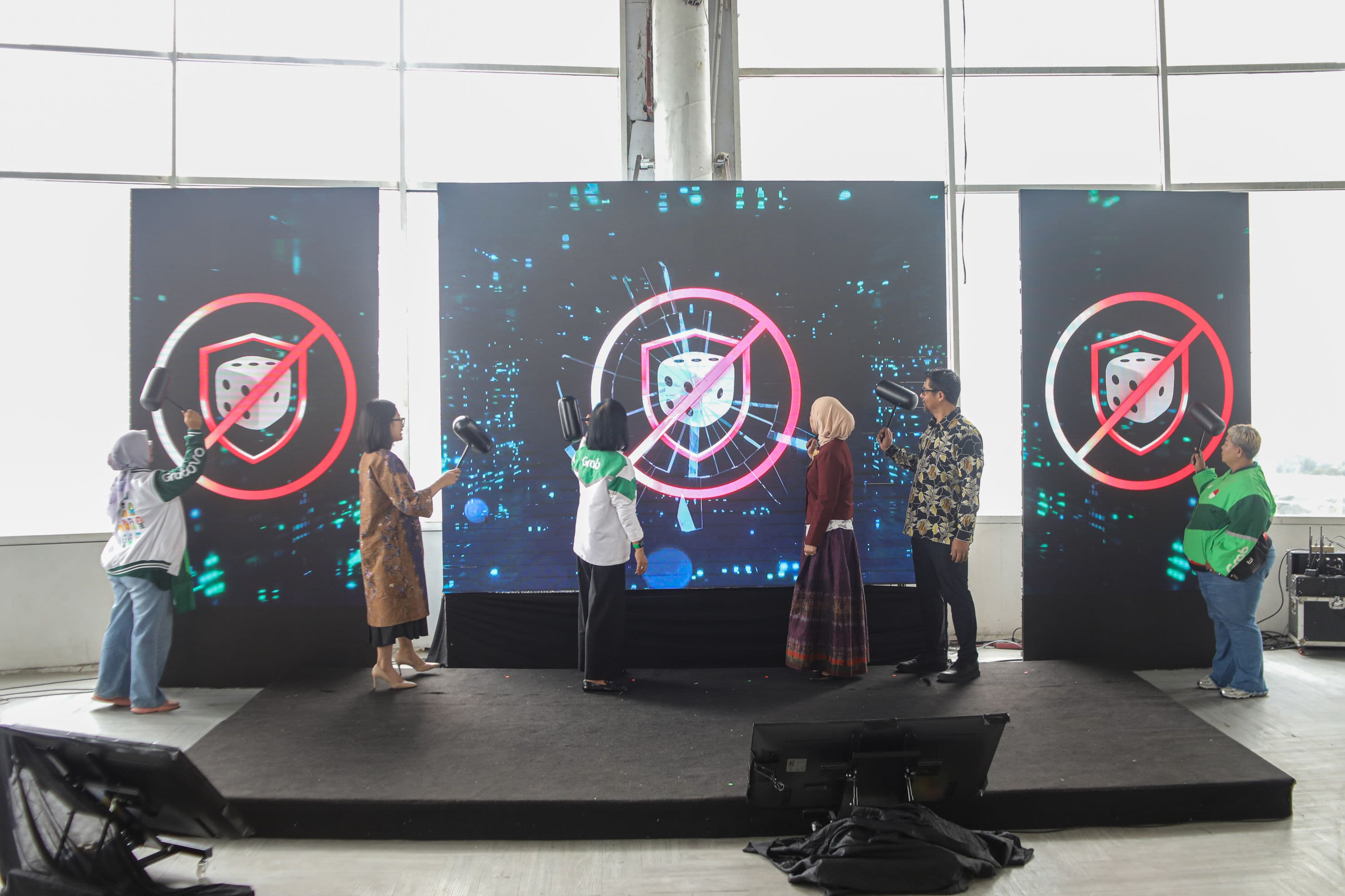Menteri Komunikasi dan Digital Meutya Hafid (ketiga kanan), Chief Executive Officer (CEO) Grab Indonesia Neneng Goenadi (ketiga kiri) memukul layar saat peluncuran GEBUK JUDOL (Gerakan Bareng Ungkap Judi Online) Ronde 3 di Jakarta, Kamis (1/10/2026). AKURAT.CO/Endra Prakoso