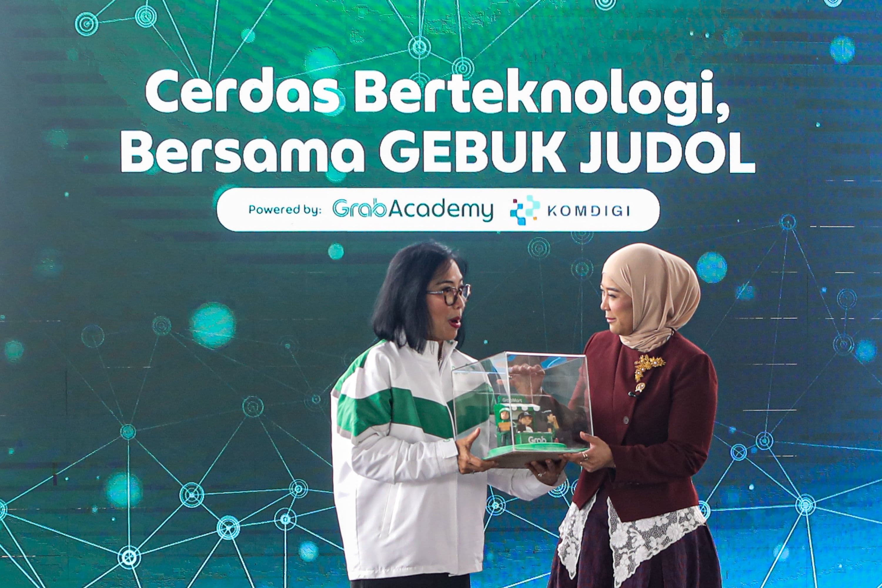 Chief Executive Officer (CEO) Grab Indonesia Neneng Goenadi (kiri) memberikan cenderamata kepada Menteri Komunikasi dan Digital Meutya Hafid (kanan) saat peluncuran GEBUK JUDOL (Gerakan Bareng Ungkap Judi Online) Ronde 3 di Jakarta, Kamis (1/10/2026). AKURAT.CO/Endra Prakoso
