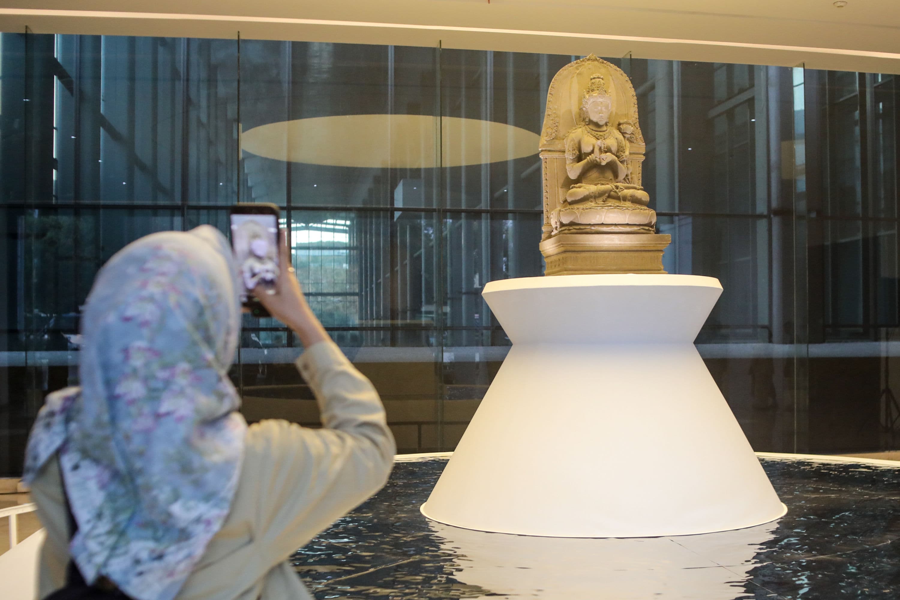Pengunjung memotret arca Prajnaparamita usai diresmikan di Museum Nasional Indonesia, Jakarta, Selasa (13/10/2026). AKURAT.CO/Endra Prakoso