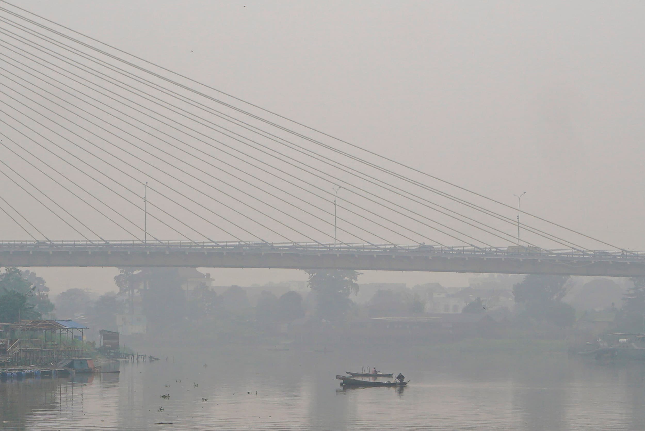 Perahu nelayan melintasi Sungai Siak yang dipenuhi kabut asap di Pekanbaru, Riau, Rabu (7/10/2026). ANTARA FOTO/Rony Muharrman/YU